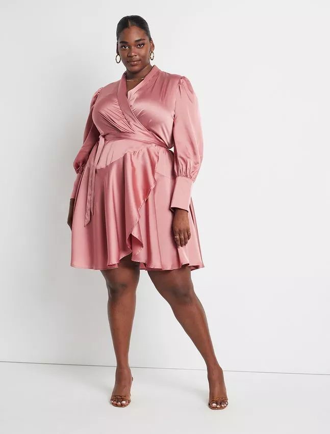 Plus size woman wearing a blush pink wrap dress for a baby shower