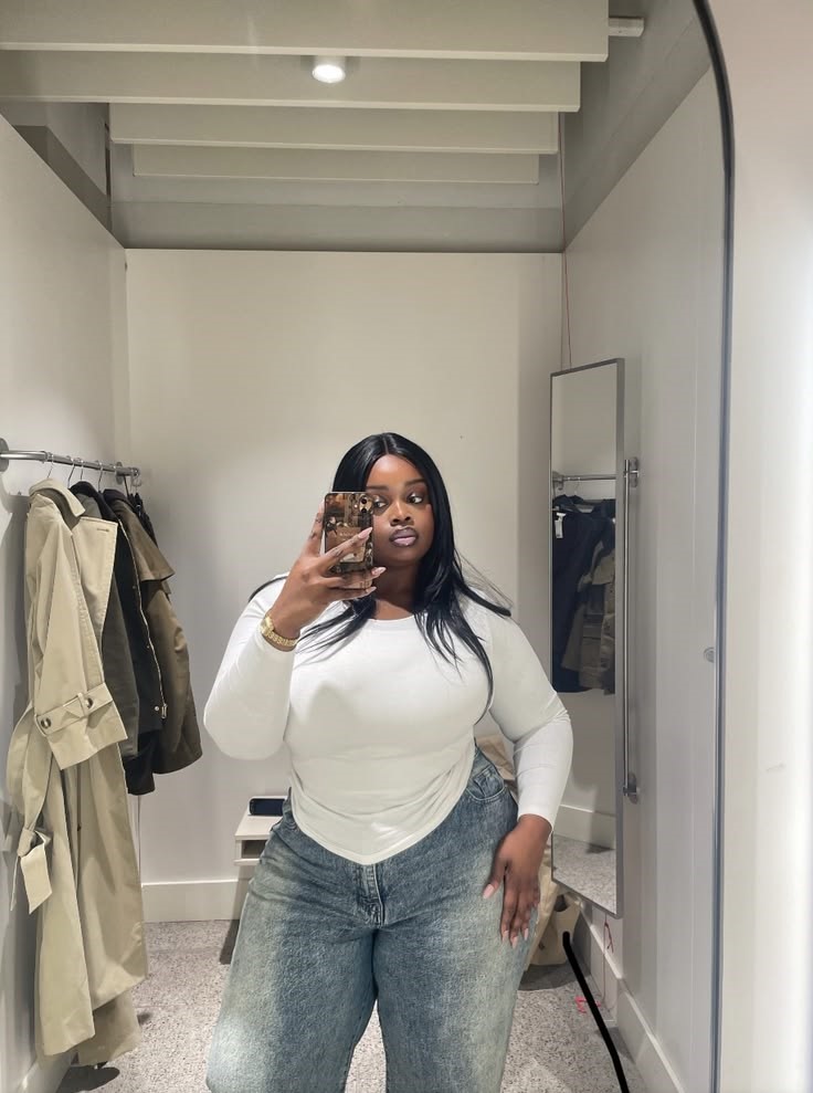 Plus size woman in a white top and wide-leg jeans showing why the fashion rule that's holding too many women back doesn't have to apply