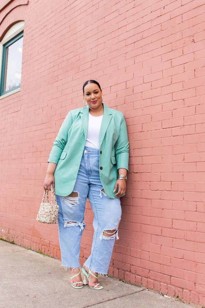 Plus size woman wearing a mint blazer and jeans, challenging the fashion rule that's holding too many women back