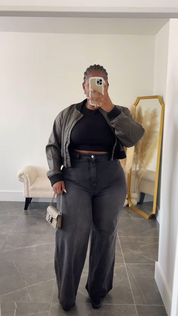 How to style black jeans with a gray jacket, black top, and neutral handbag