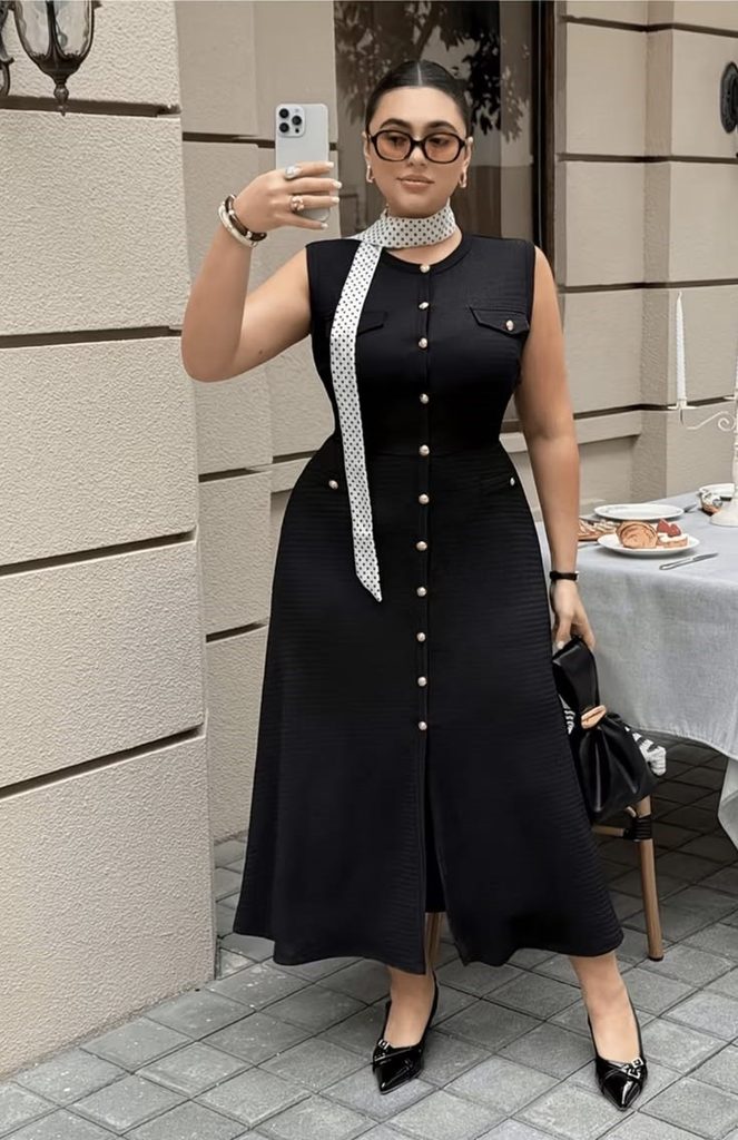 Curvy woman wearing an elegant black midi dress with accessories for old money style