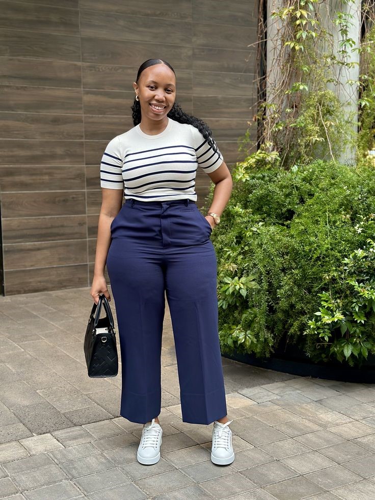 Curvy woman wearing a striped knit top with tailored navy pants for old money style