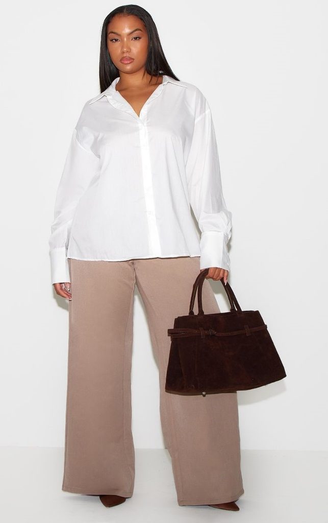 Curvy woman wearing a white button-down shirt with wide-leg trousers for old money style