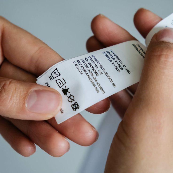 Person checking a clothing care label to avoid online shopping mistakes plus size women make