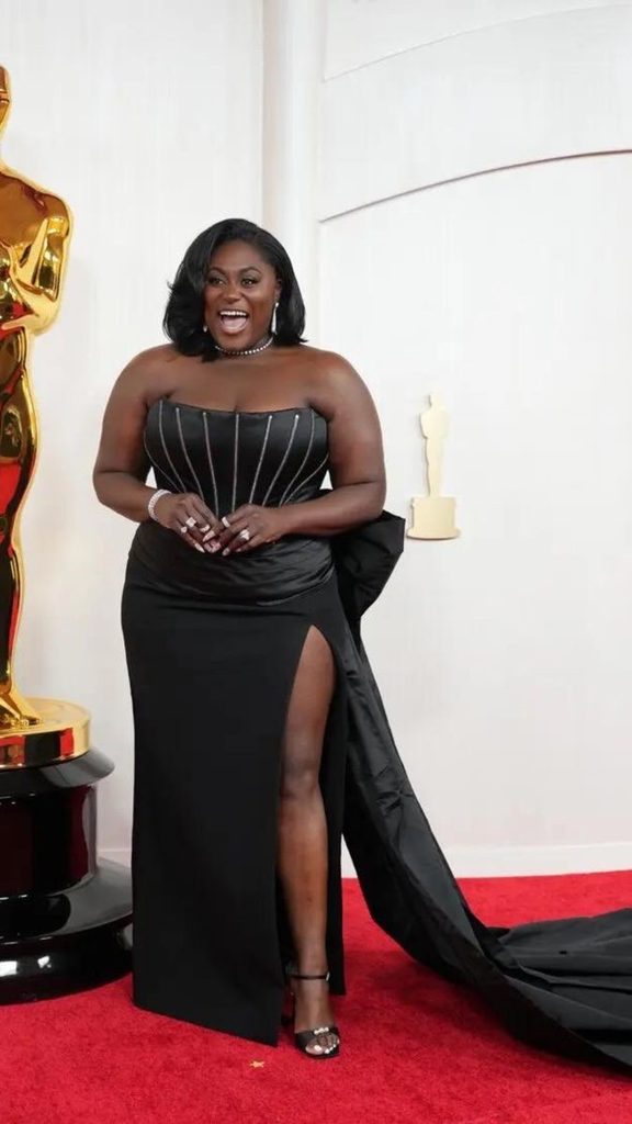 Red carpet looks for curvy women featuring a black gown with a dramatic train and thigh-high slit