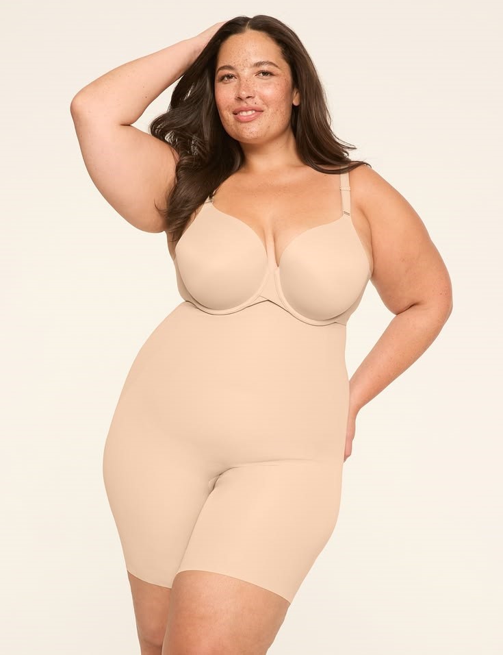 Plus size woman wearing beige full-body shapewear while challenging shapewear myths