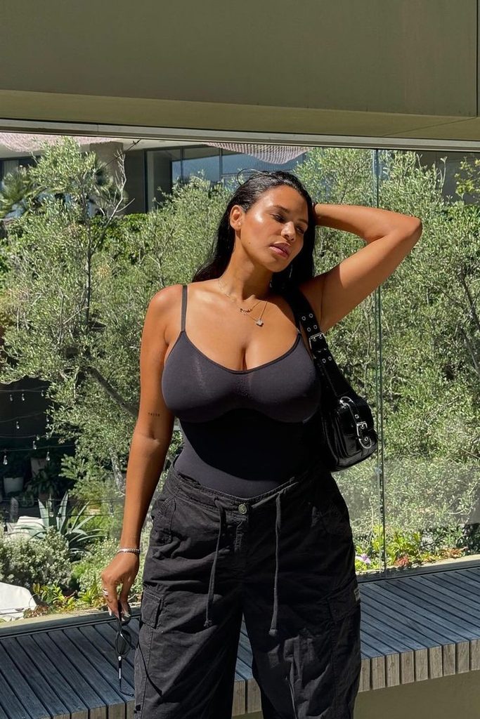 Plus size woman wearing a black shapewear bodysuit with an everyday outfit
