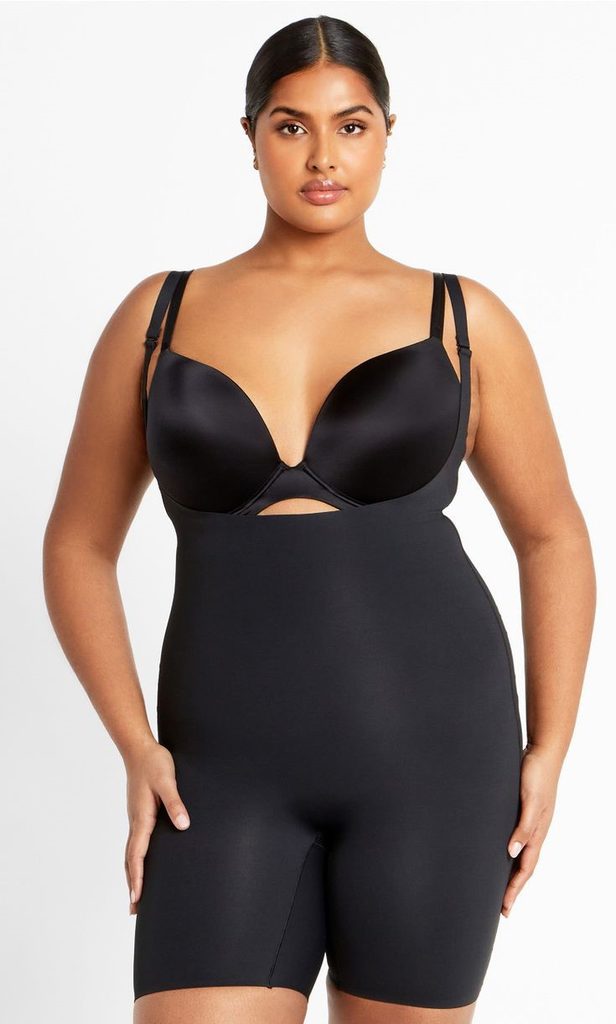 Plus size woman wearing black shapewear with a bra while breaking shapewear myths