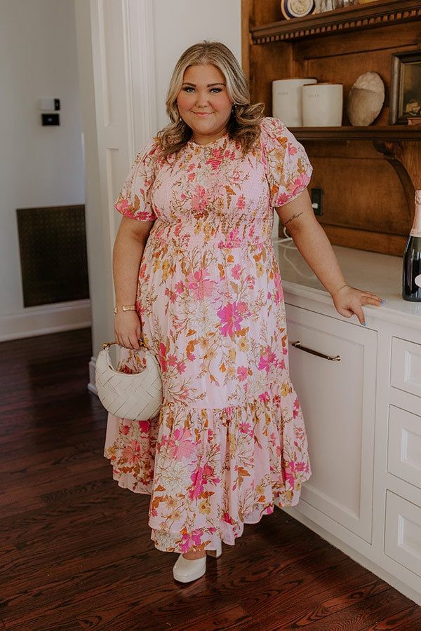 Plus size woman wearing a soft floral midi dress as a baby shower outfit