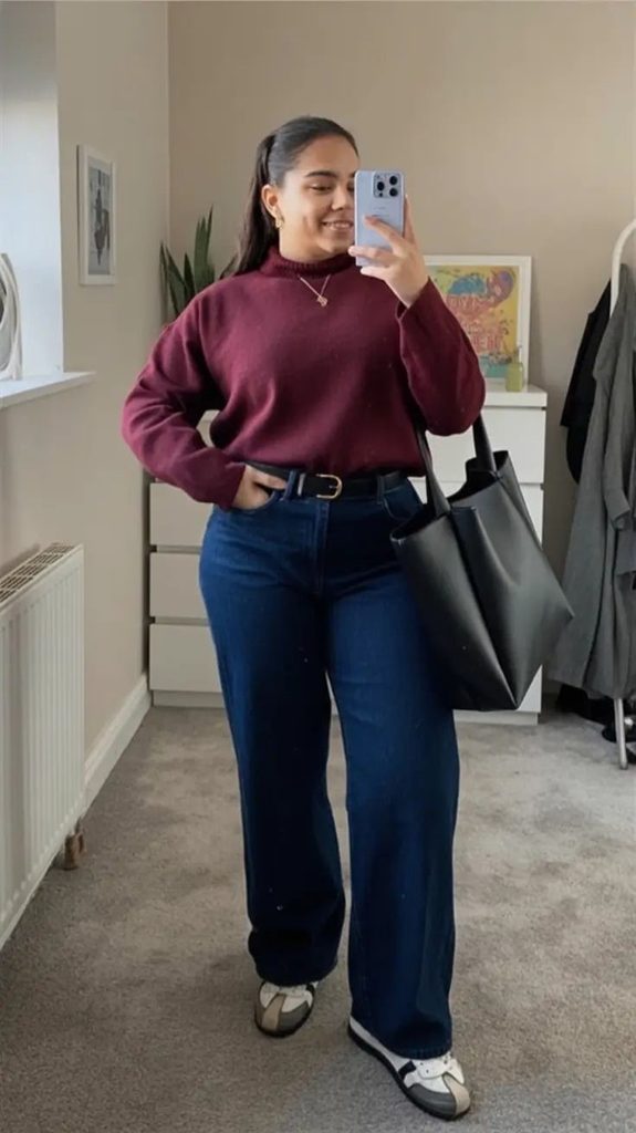 Plus size woman wearing straight-leg jeans with a burgundy sweater