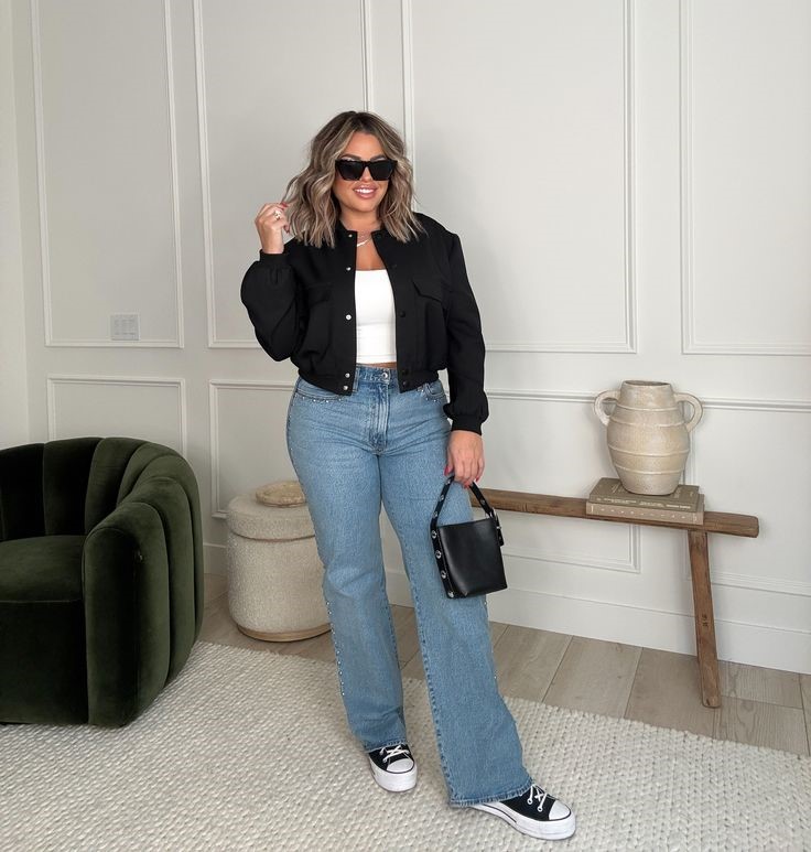 Plus size woman wearing straight-leg jeans with a cropped black jacket