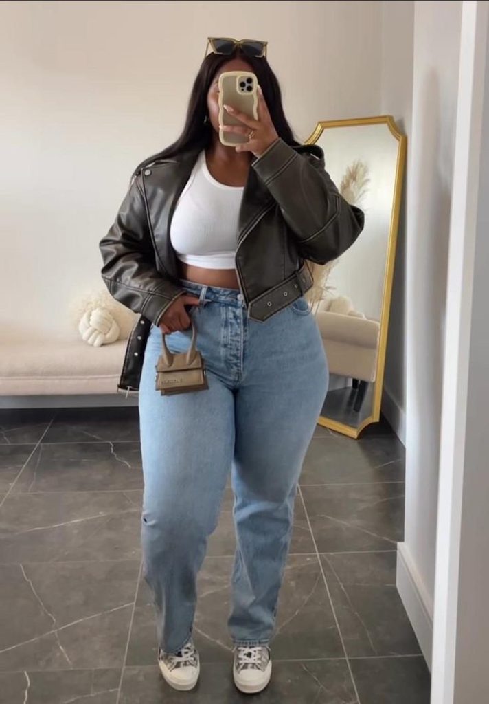 Plus size woman wearing straight-leg jeans with a black leather jacket