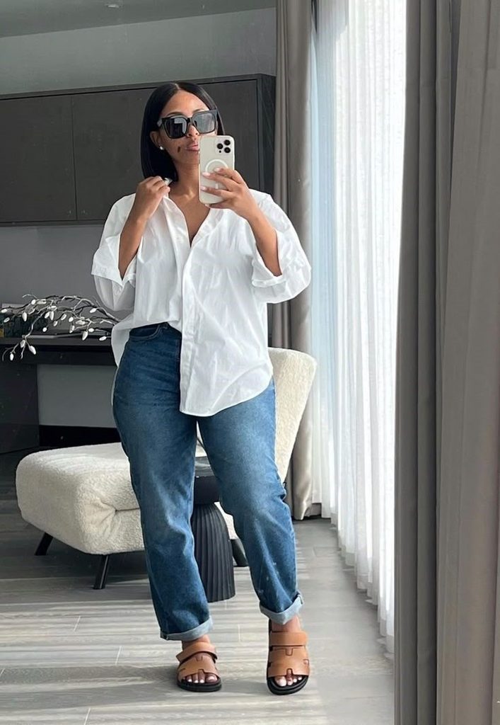 Plus size woman wearing straight-leg jeans with an oversized white shirt
