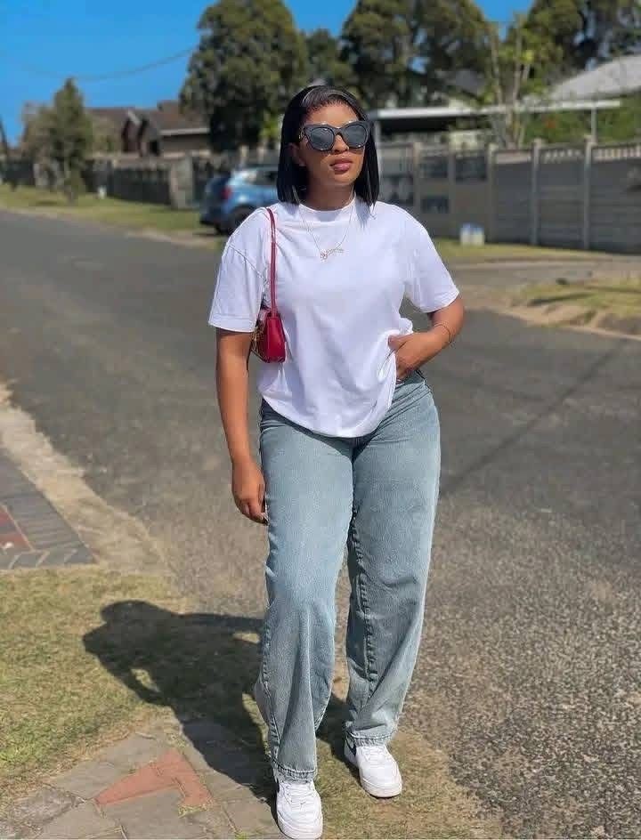 Plus size woman wearing straight-leg jeans with a relaxed white T-shirt