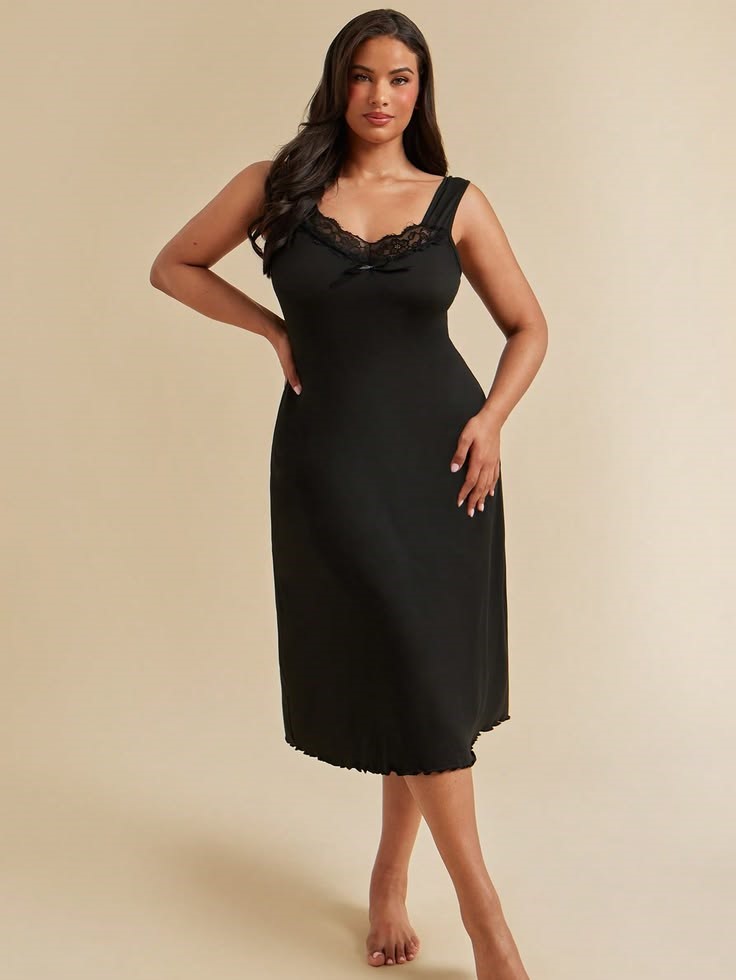 Black knee-length slip dress with lace neckline on a plus size woman