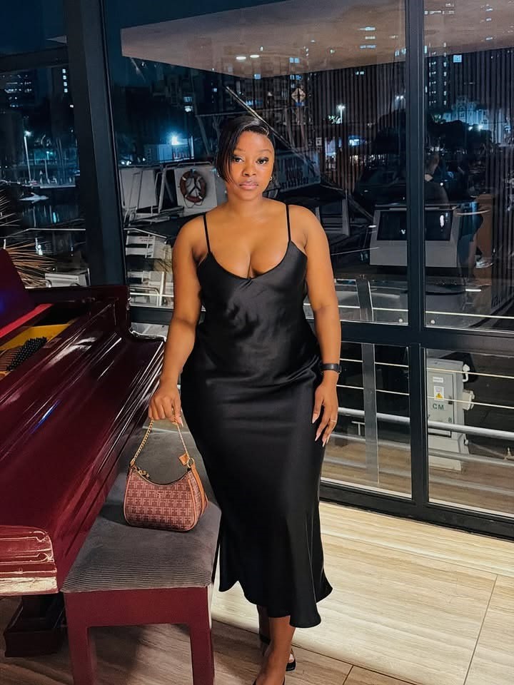 Plus size woman wearing a black satin midi dress, showing the one dress style wedding guests always love