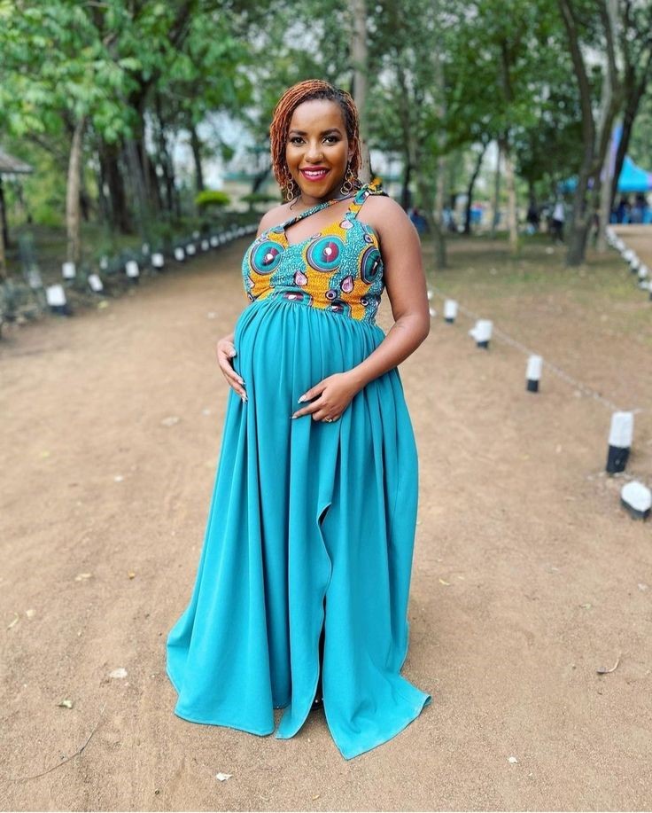 Pregnant plus size woman wearing a turquoise empire-waist maxi dress for a baby shower