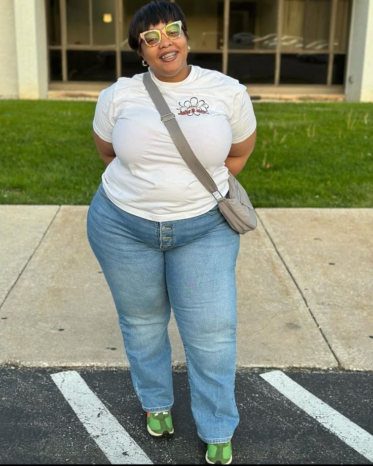 Plus size woman smiling in a white T-shirt and jeans