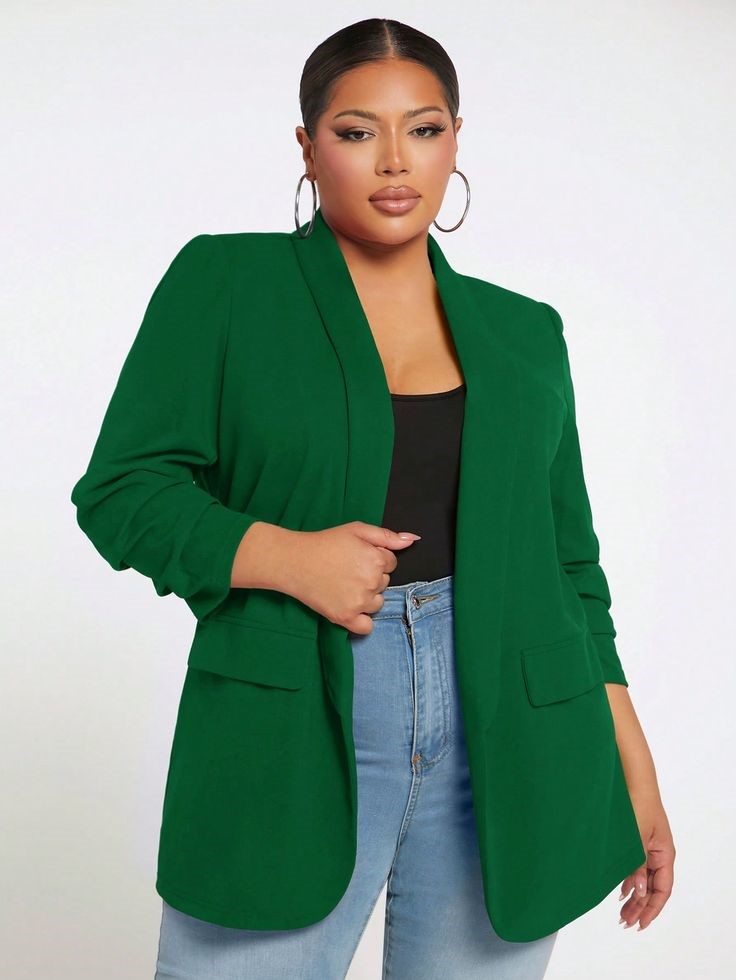 Plus size woman wearing a longline green blazer with jeans