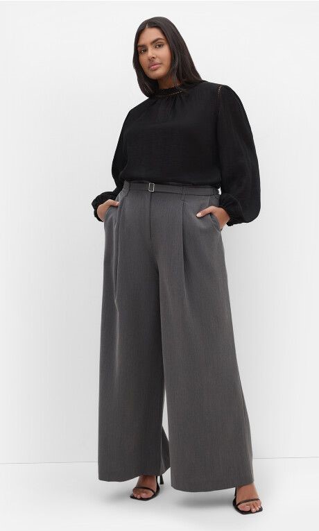Business casual outfits for plus size women featuring a long-sleeved top and tailored trousers.