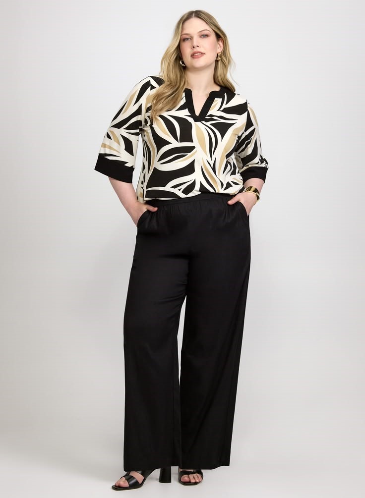 Business casual outfits for plus size women featuring a printed blouse and solid-colored tailored trousers.