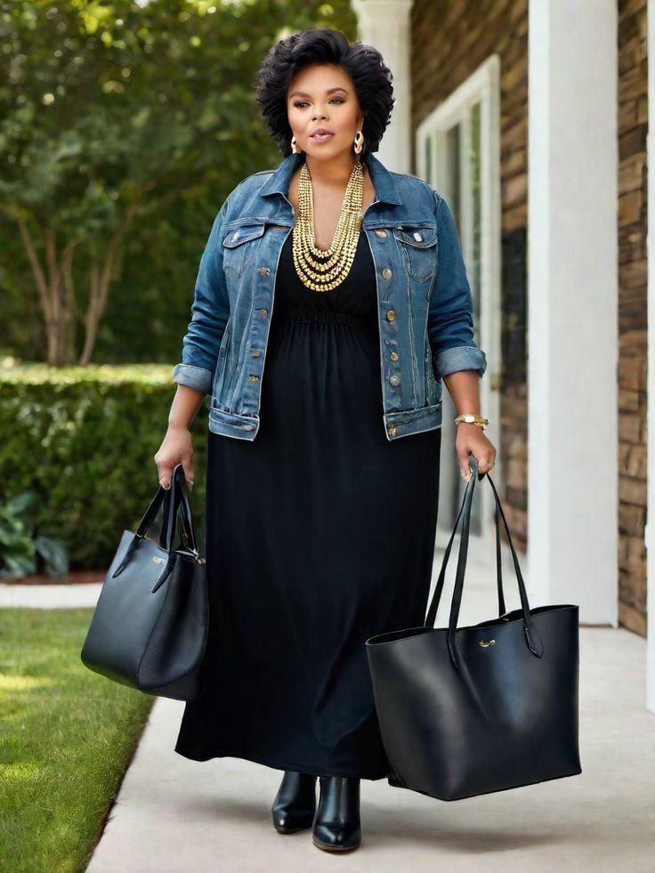 Plus size denim jacket outfit with a black maxi dress, black ankle boots, and a statement gold necklace.