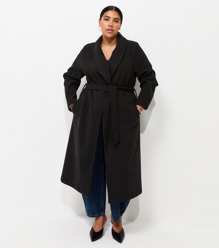 Long coat outfit ideas featuring a black belted coat, blue jeans, and black pointed-toe heels