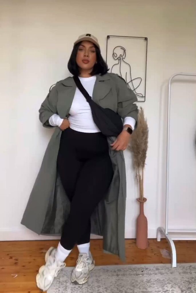 Long coat outfit ideas featuring an olive green long coat, black leggings, white top, and chunky sneakers