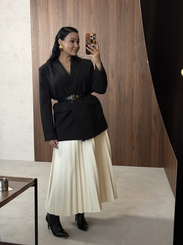 Neutral Outfit Ideas featuring a black belted blazer, cream pleated midi skirt, and black ankle boots.