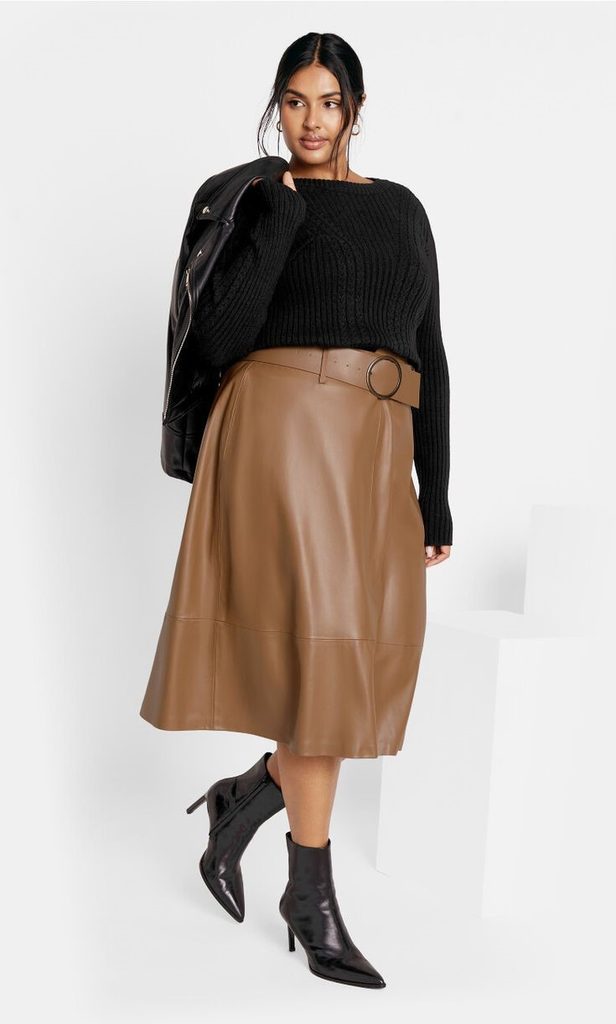 Neutral Outfit Ideas featuring a black ribbed sweater, brown leather midi skirt, matching belt, and black ankle boots.