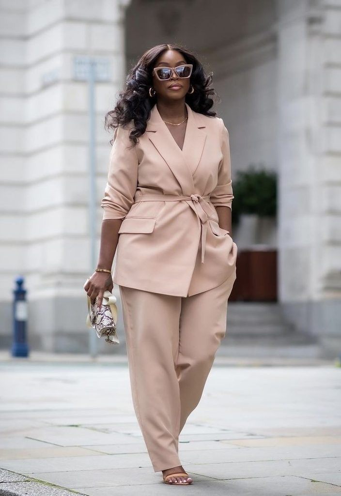 Plus size woman wearing a beige belted blazer and matching trousers, a polished choice for neutral outfit ideas.