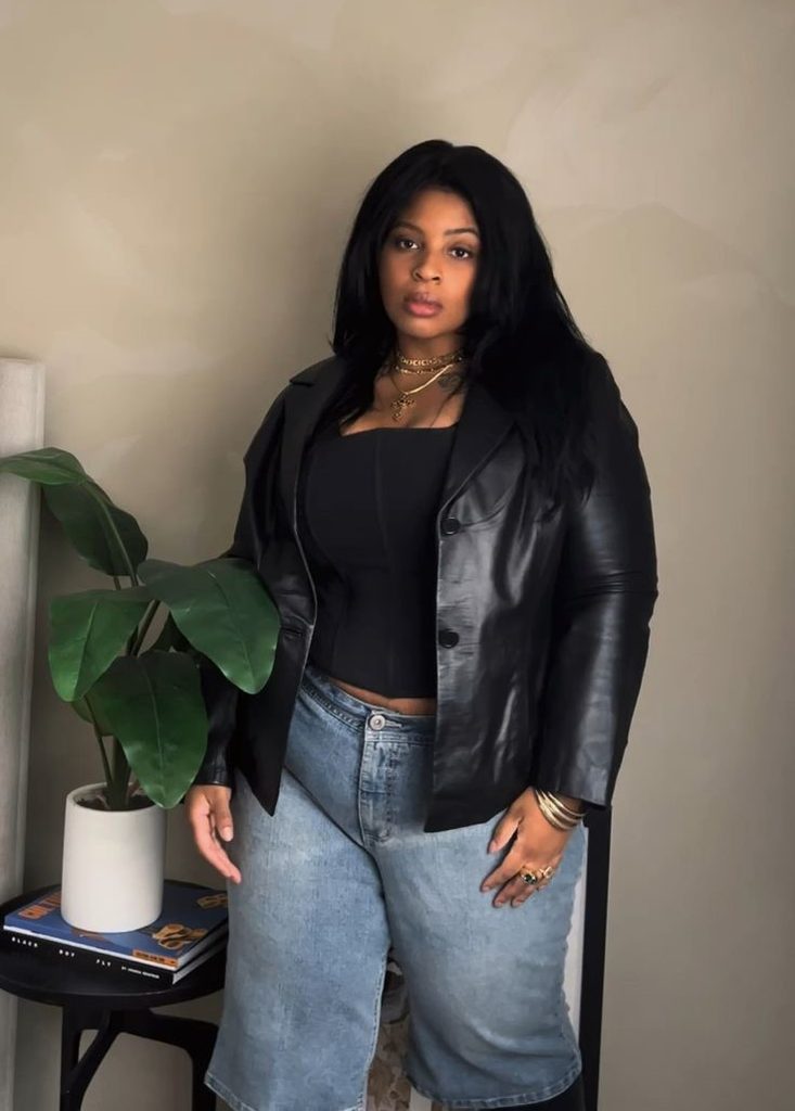 Plus size leather jacket outfit ideas featuring a black leather blazer, black fitted top, and light-wash denim Bermuda shorts