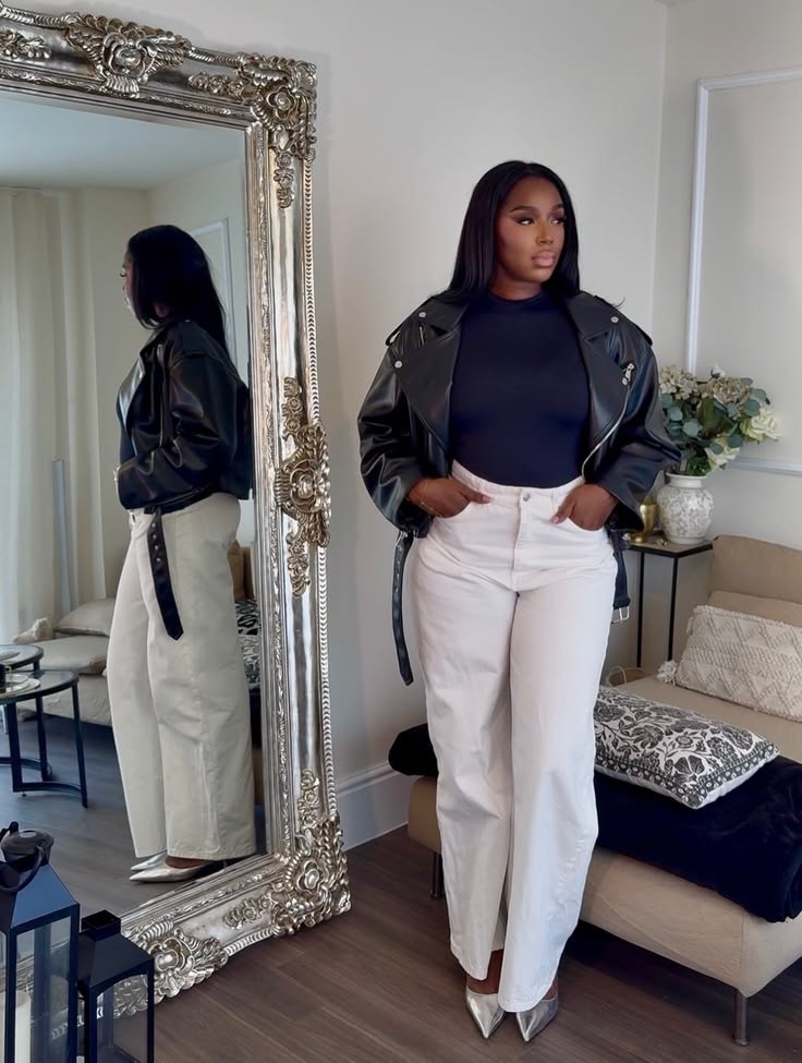 Plus size leather jacket outfit ideas featuring a black leather jacket, navy fitted top, white wide-leg jeans, and pointed-toe heels
