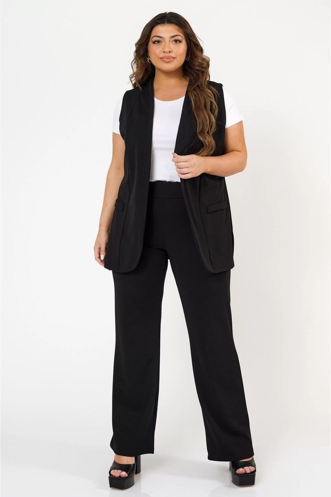 Minimalist fashion for plus size women wearing a longline vest with straight-leg trousers.