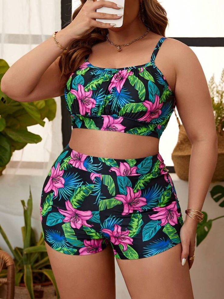 Plus size swimsuits featuring a black tropical-leaf print two-piece with a cropped swim top and matching high-waisted shorts.