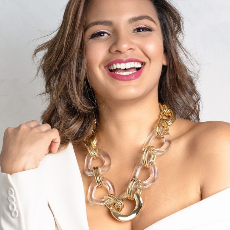Statement Necklace Styling Guide featuring an oversized gold and clear link necklace with a white outfit