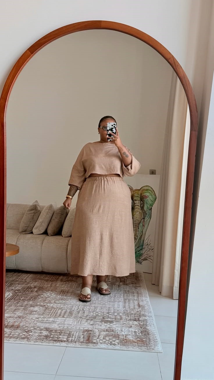 Plus size woman checking a coordinated outfit in the mirror and considering why her outfit feels off